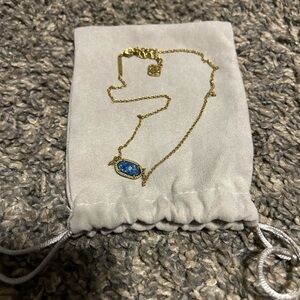 Gold Kendra Scott necklace with navy blue stone